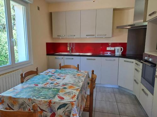 une cuisine avec une table et des placards blancs dans l'établissement Maison spacieuse et conviviale à Saint-Alban avec jardin, à Saint-Alban