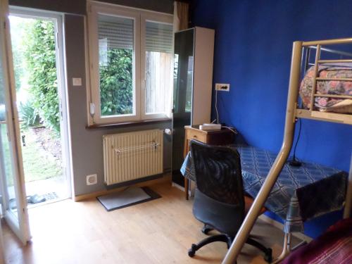 a bedroom with a bunk bed and a chair at Studio-appartement à proximité d'une maison de Maître de 1904 in Haguenau