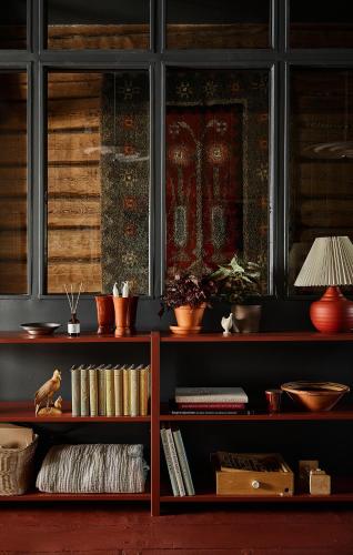 a book shelf filled with books next to a window at Stay North Matri House Edla in Mathildedal