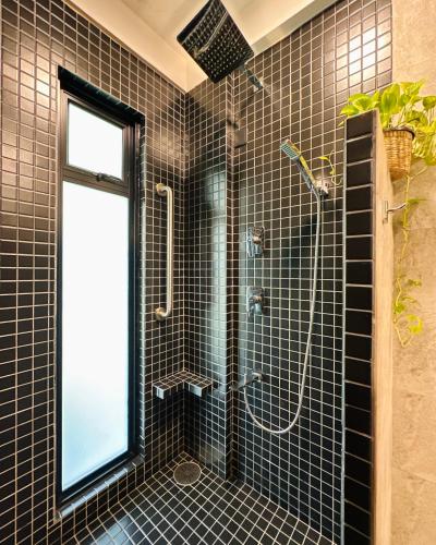 a black tiled bathroom with a shower and a window at Villa Vikasa Colombo in Colombo