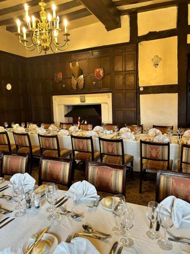 a dining room with tables and chairs and a chandelier at Albright Hussey Manor in Shrewsbury