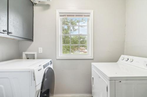 a white kitchen with a washing machine and a window at 5BR with Game Room & Huge Backyard in Lawrenceville
