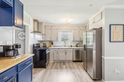 a kitchen with white cabinets and a stainless steel refrigerator at 5BR with Game Room & Huge Backyard in Lawrenceville