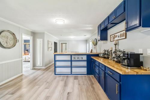 a kitchen with blue cabinets and a wooden floor at 5BR with Game Room & Huge Backyard in Lawrenceville