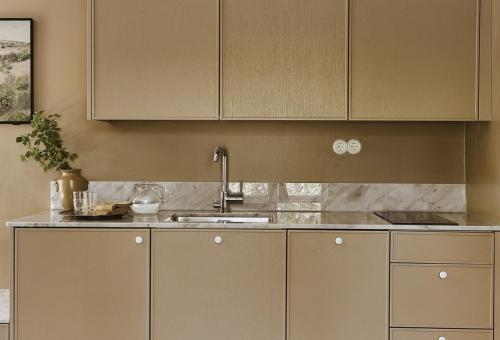 a kitchen with white cabinets and a sink at Stay North Matri House Edla in Mathildedal