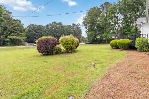 a yard with some bushes and a house at 5BR with Game Room & Huge Backyard in Lawrenceville