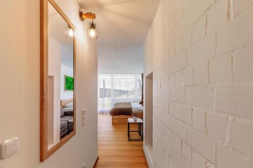 a hallway with a white brick wall and a mirror at Englmar Apartments with free WELLNESS and FITNESS in Sankt Englmar