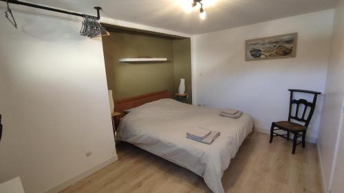 une petite chambre avec un lit et une chaise dans l'établissement Bololo House, à Leffrinckoucke