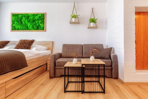 a living room with a couch and a bed at Englmar Apartments with free WELLNESS and FITNESS in Sankt Englmar
