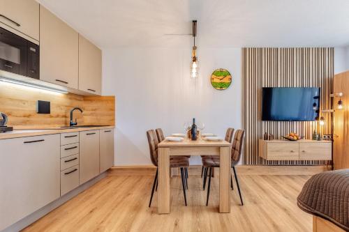 a kitchen and dining room with a table and chairs at Englmar Apartments with free WELLNESS and FITNESS in Sankt Englmar
