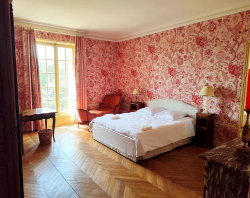 a bedroom with a bed and floral wallpaper at Château Champêtre 8 chambres, parc 18 ha, 4 étangs in Fontenoy
