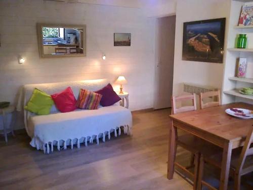 - un salon avec un canapé et des oreillers colorés dans l'établissement Agréable appartement avec jardin entre plage et forêt, à La Teste-de-Buch