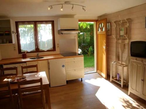 une cuisine avec un évier et une table ainsi qu'une cuisine avec une table à manger dans l'établissement Agréable appartement avec jardin entre plage et forêt, à La Teste-de-Buch