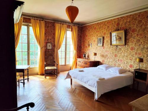 a bedroom with a large white bed and a desk at Château Champêtre 8 chambres, parc 18 ha, 4 étangs in Fontenoy
