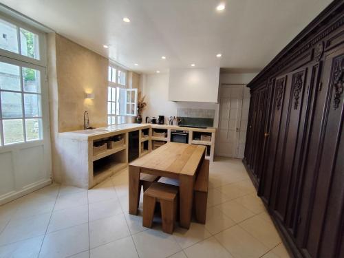 a kitchen with a wooden table and a sink at Château Champêtre 8 chambres, parc 18 ha, 4 étangs in Fontenoy