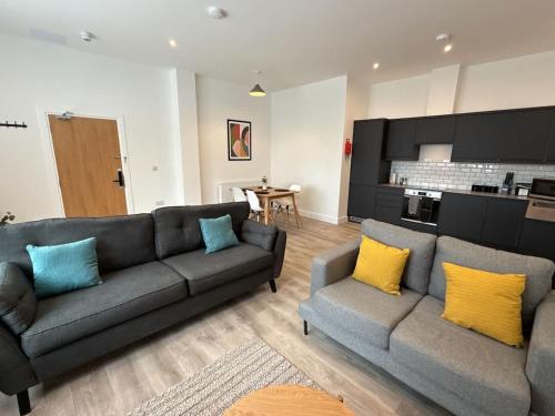 un salon avec deux canapés et une cuisine dans l'établissement Luxury 2 bedroom 2 bathroom All ground floor centrally located - 1 Queen Street - Ashbrook Serviced Apartments, à Abingdon