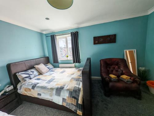 a bedroom with a bed and a leather chair at Double Rooms near Bournemouth Hospital ensuite or shared bathroom options in Bournemouth