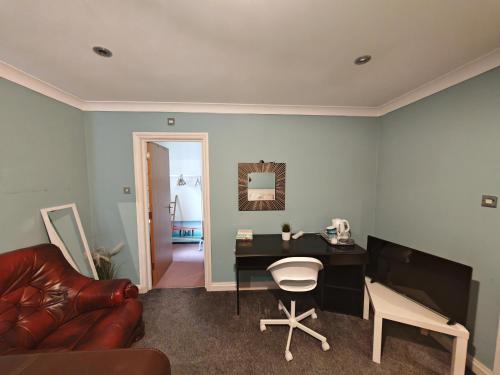 a living room with a desk and a couch at Double Rooms near Bournemouth Hospital ensuite or shared bathroom options in Bournemouth