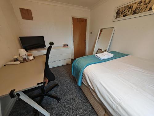 a bedroom with a bed and a desk with a computer at Double Rooms near Bournemouth Hospital ensuite or shared bathroom options in Bournemouth