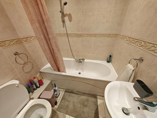 a bathroom with a tub and a toilet and a sink at Double Rooms near Bournemouth Hospital ensuite or shared bathroom options in Bournemouth