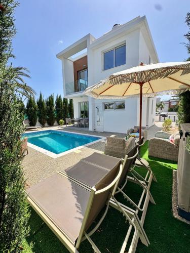 a villa with a swimming pool and a house at Villa Jarvis Modern and Quiet 3BR with Private Swimming Pool in Paralimni