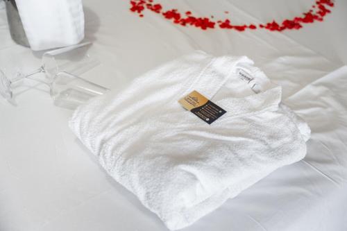 un maglione bianco con un'etichetta su un letto di Hotel Lula Ksamil a Ksamil