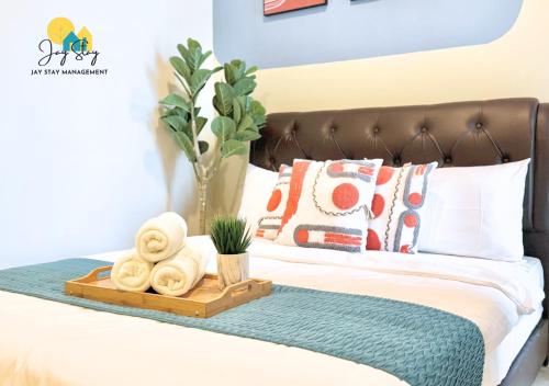 a bed with a wooden tray with towels on it at The Shore l Luxury 3BR l 6-9pax l Direct Mall Access l City Centre l Melaka River l Jonker Street by Jay Stay Management in Melaka