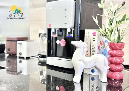 a small white horse on a counter next to a coffee maker at The Shore l Luxury 3BR l 6-9pax l Direct Mall Access l City Centre l Melaka River l Jonker Street by Jay Stay Management in Melaka