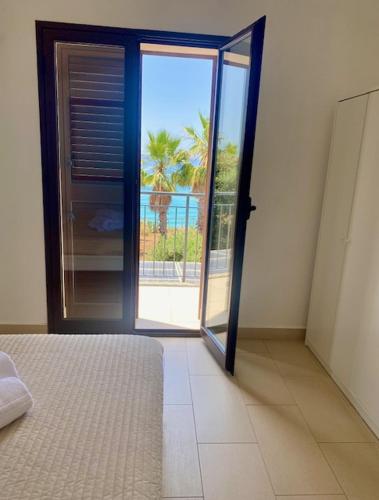a bedroom with an open door with a view of the ocean at Bellavista in Realmonte