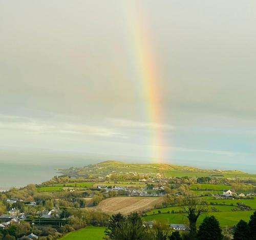 a rainbow in the sky over a town at Comfortable Home in Quiet Coastal Community in Dungarvan