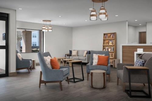 a living room with chairs and tables in a room at Candlewood Suites Annapolis by IHG in Annapolis