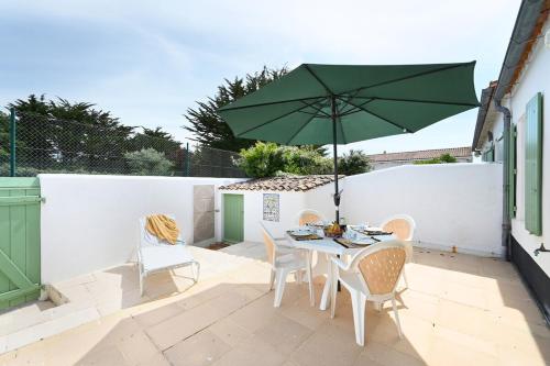 - une table et des chaises avec un parasol vert sur la terrasse dans l'établissement 080 Domaine 80 Courtyard, pool, tennis, à La Couarde-sur-Mer