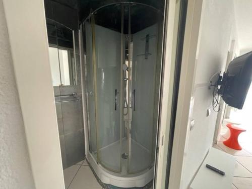 une douche avec une porte vitrée dans une salle de bain dans l'établissement Première ligne mer Appartement t2 cabine pour 4 personnes N123, à Palavas-les-Flots