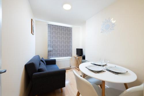 a living room with a white table and a blue couch at Charmstay King's Cross in London