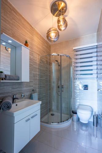 a bathroom with a shower and a sink and a toilet at Bugibba - Central Luxury Seafront, only for family in St. Paul's Bay
