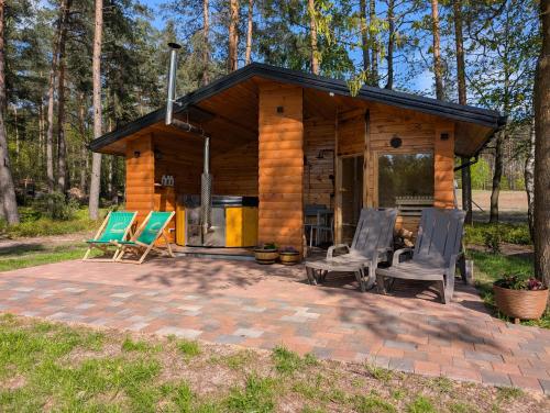 a log cabin with rocking chairs and a fireplace at Leśna Przystań Nowy Kobrzyniec in Kobrzyniec Nowy