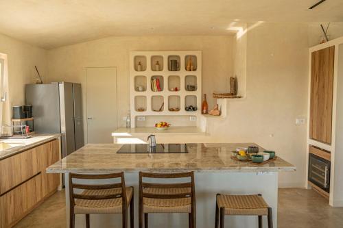 a kitchen with a large island with bar stools at Tenuta le Menadi in Noto