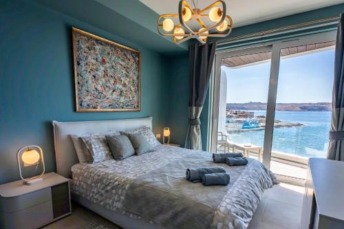 a bedroom with a large bed with a large window at Bugibba - Central Luxury Seafront, only for family in St. Paul's Bay