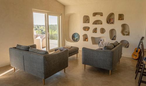 a living room with two couches and a guitar at Tenuta le Menadi in Noto