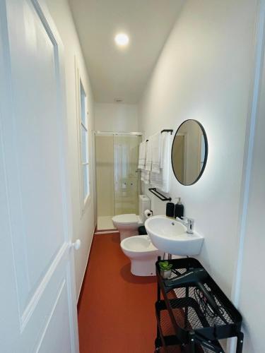 a bathroom with two toilets and a sink and a mirror at Casa da Arquitectura - Texturas in Angra do Heroísmo