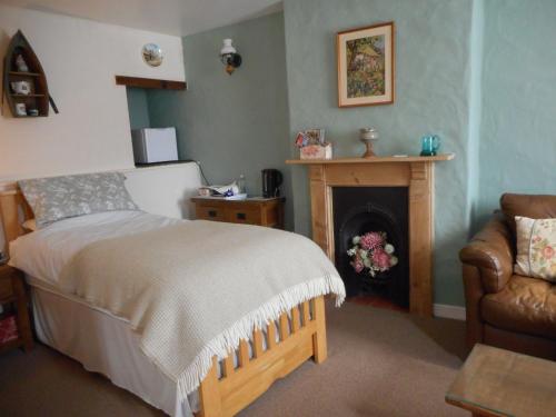 a bedroom with a bed and a fireplace and a chair at Glascoed Farmhouse in Carmarthen