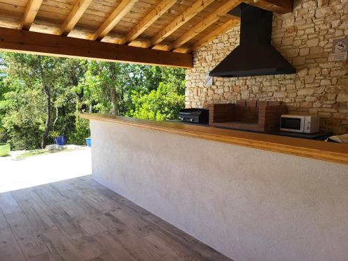 une cuisine avec un comptoir et un four micro-ondes sur un mur dans l'établissement Villa contemporaine tout confort, à Saint-Julien-de-Peyrolas