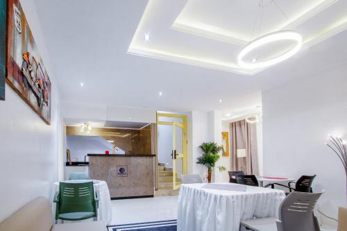 a dining room with white tables and chairs and a kitchen at Wallgate Apartments Limited in Jahi