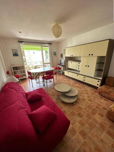 un salon avec un canapé rouge et une table dans l'établissement Centre ville Appartement t2 pour 3 personnes N2 114, à La Grande Motte