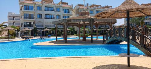 a swimming pool with a bridge in front of a building at Sharm hills sea view in Sharm El Sheikh