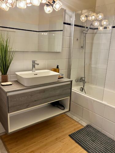 une salle de bain avec un lavabo, une douche et une baignoire dans l'établissement Maison Les Charmes - Clos Fontaine 4/5 personnes, à Saint-Cibard