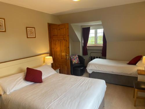 a hotel room with two beds and a chair at Ashfield House Failte Ireland Approved Bed and Breakfast in Cong