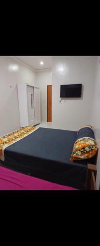 a bedroom with two beds and a tv on the wall at RR Deck Betolandia in Juazeiro do Norte