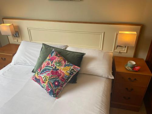 a bed with a pillow on it with a night stand at Ashfield House Failte Ireland Approved Bed and Breakfast in Cong