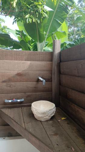 a bathroom with a toilet sitting on a wall at The Ridge Surf Lodge in Biha